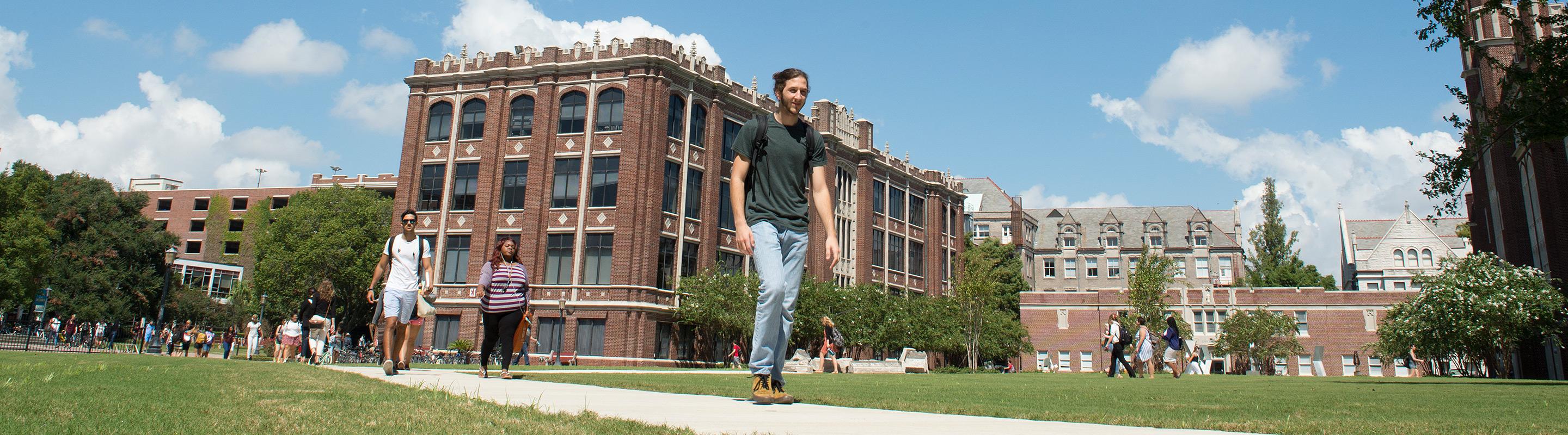 Student walking through academic quad in the middle of the day