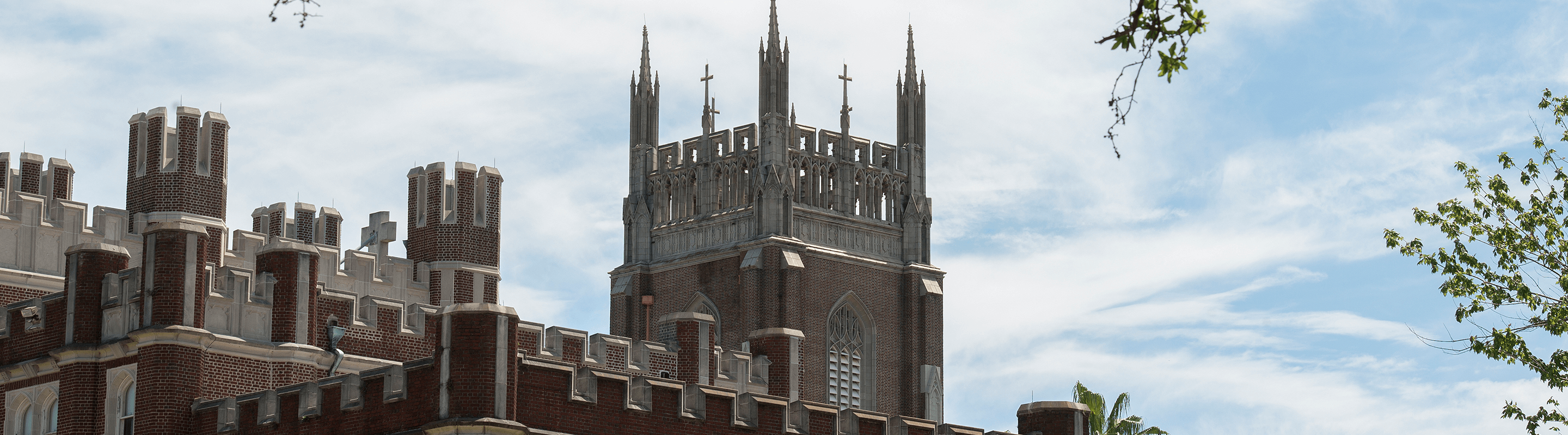 Image of tower of Marquette Hall against blue sky, 3/4 view