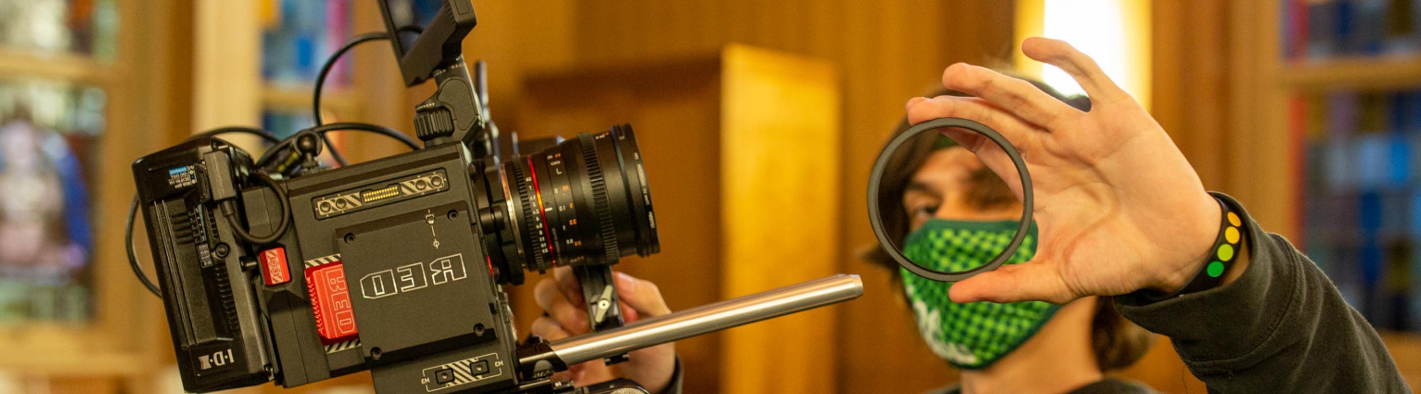 Student putting lens on a RED Camera